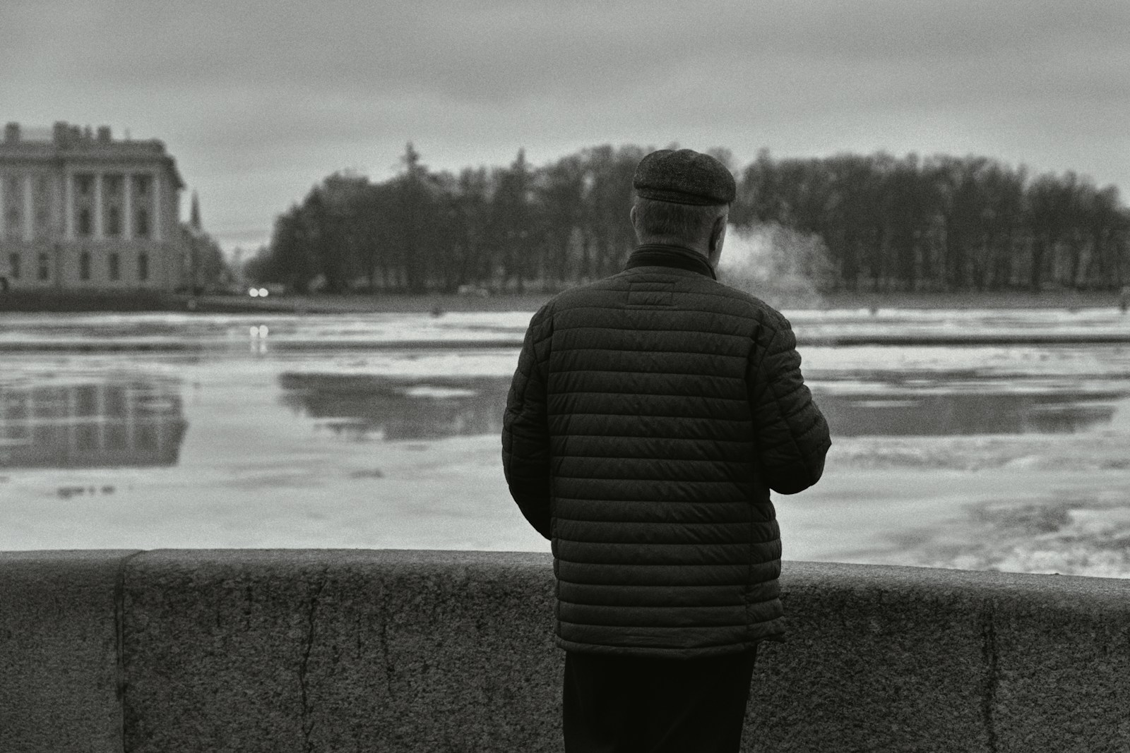 a man standing on a wall looking at a body of water